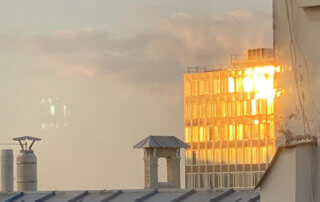 Soleil couchant se reflétant sur la façade d'un immeuble, Paris 19e (75)