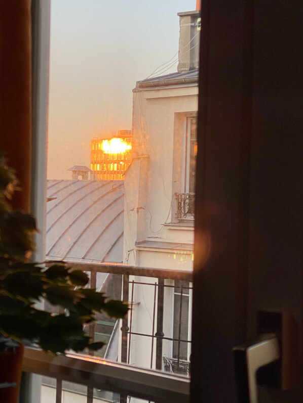 Soleil couchant se reflétant sur la façade d'un immeuble, vu par une des fenêtres de mon appartement, Paris 19e (75)