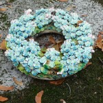 Couronne de fleurs de myosotis en céramique sur une tombe du cimetière du Père Lachaise, Paris 20e (75)